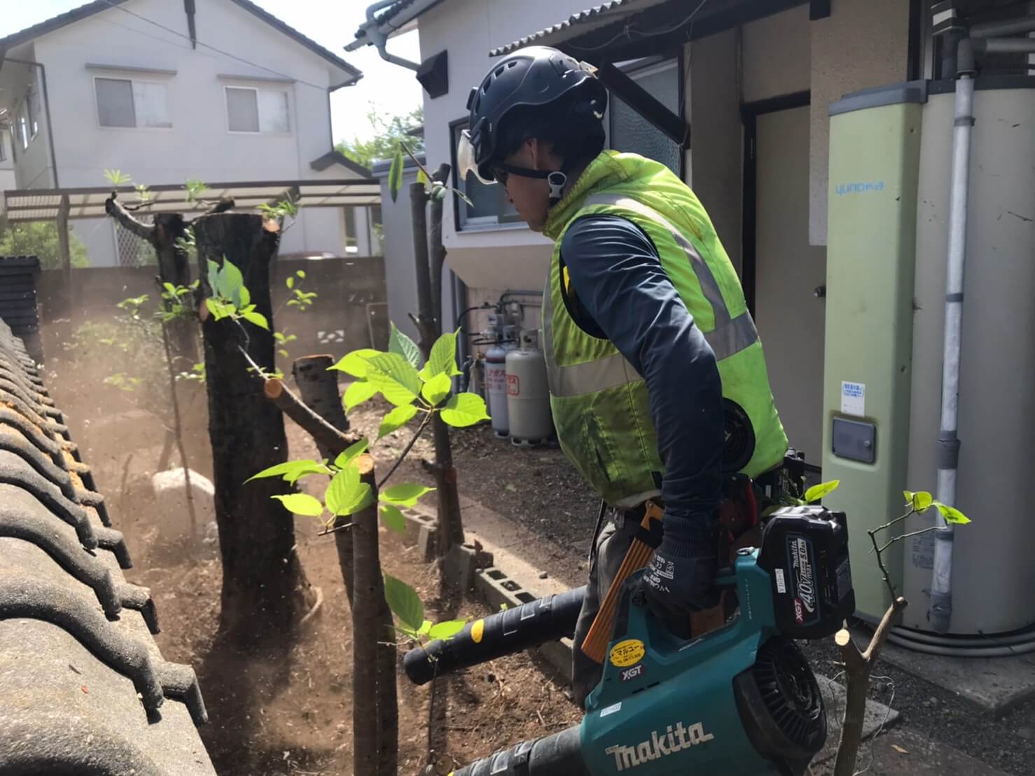 細かいゴミをブロワーでとばして一箇所に集める田嶋。